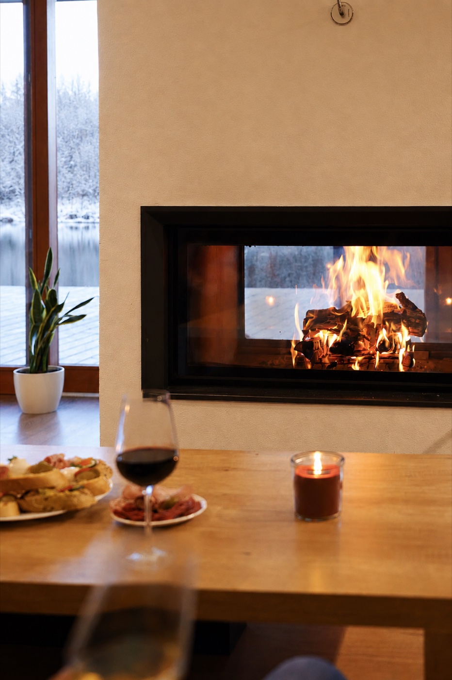 Fireplace with a burning fire and a glass of wine at the House on the Water